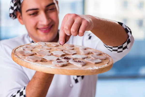 Young man cooking cookies in kitchen — Stock Photo, Image