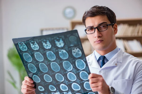 Médico jovem olhando para tomografia computadorizada imagem de raios-x — Fotografia de Stock