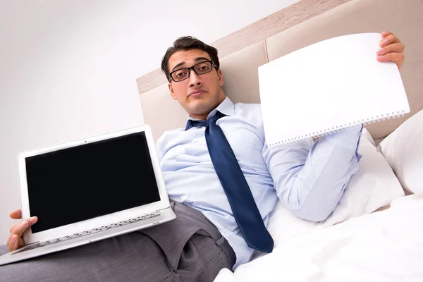 Бізнесмен працює в ліжку вдома — стокове фото