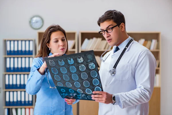 Young doctor looking at computer tomography x-ray image — Stock Photo, Image