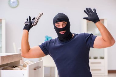 Soyguncu kar maskesi takıp değerli şeyler çalıyor.