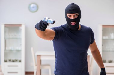 Soyguncu kar maskesi takıp değerli şeyler çalıyor.