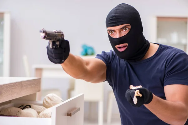 Ladrão usando balaclava roubando coisas valiosas — Fotografia de Stock