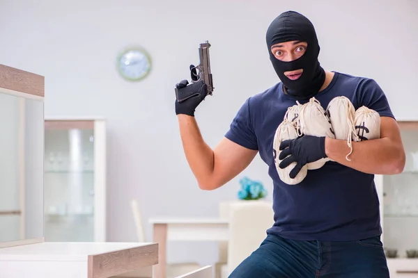 Ladrão usando balaclava roubando coisas valiosas — Fotografia de Stock