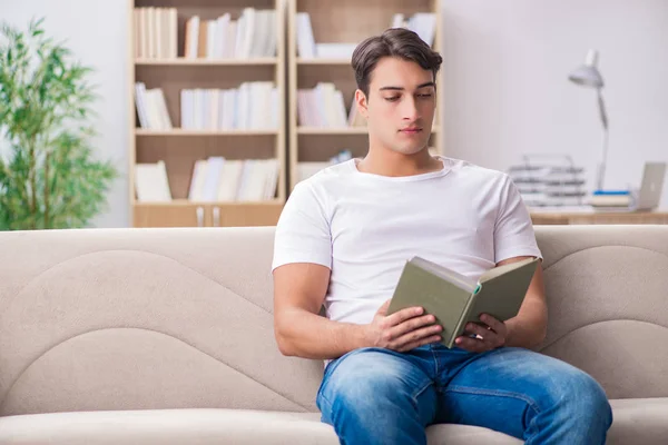 Homme lisant le livre assis dans le canapé — Photo