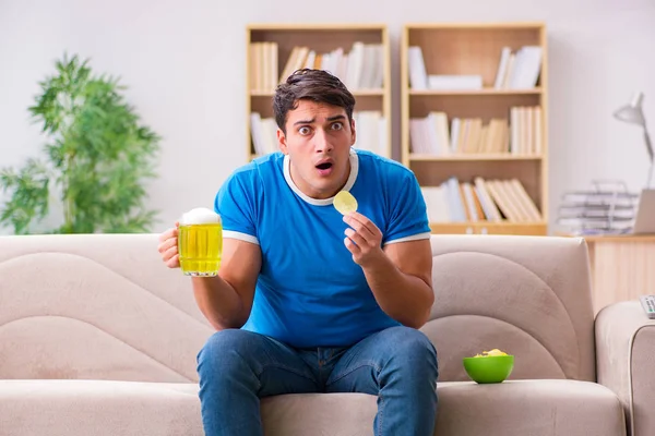 Man watching football at home sitting in couch — Stock Photo, Image