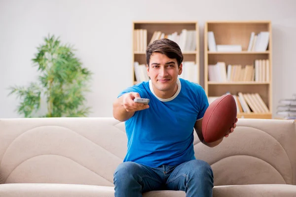 Hombre viendo fútbol en casa sentado en el sofá — Foto de Stock