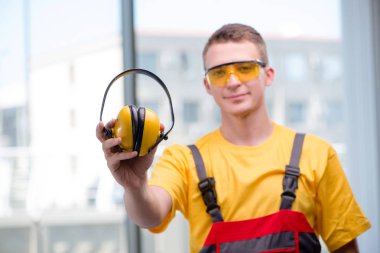 Sarı tulumlu genç inşaat işçisi.