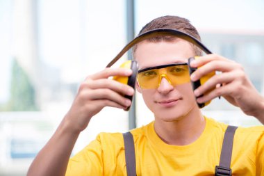 Sarı tulumlu genç inşaat işçisi.