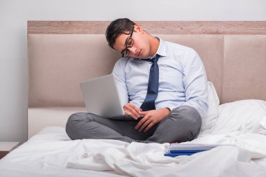 İş adamı evdeki yatakta çalışıyor.
