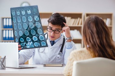 Genç doktor bilgisayardaki röntgen görüntülerine bakıyor.