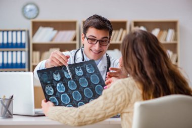 Genç doktor bilgisayardaki röntgen görüntülerine bakıyor.