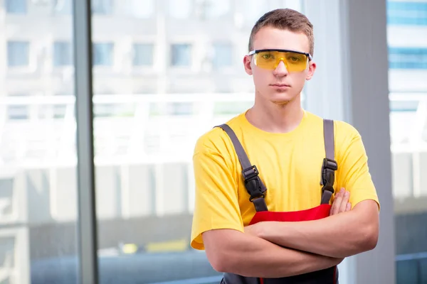 Joven trabajador de la construcción en mono amarillo — Foto de Stock