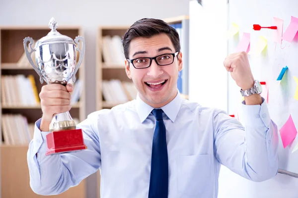 Young businessman receiving prize cup in office — Stock Photo, Image