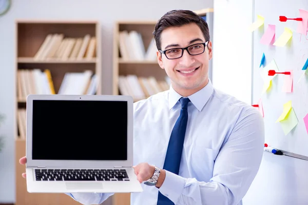 Ung affärsman visar skärmen på sin laptop — Stockfoto