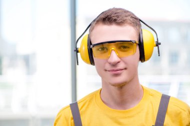 Sarı tulumlu genç inşaat işçisi.