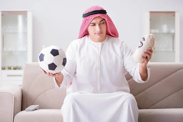 Jonge Arabier man kijkt voetbal zittend op de bank — Stockfoto
