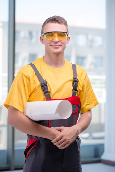 Młody pracownik budowlany w żółtych kombinezonach — Zdjęcie stockowe
