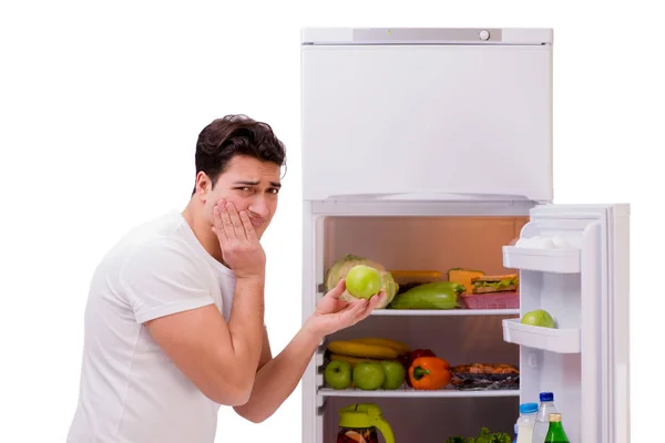 Homem ao lado do frigorífico cheio de comida — Fotografia de Stock