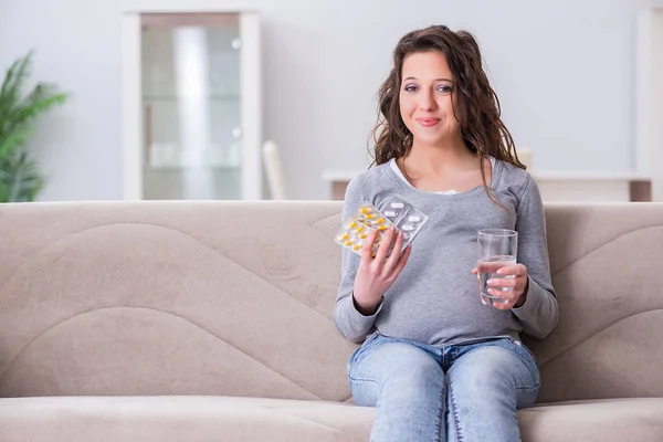 Mulher grávida sentada no sofá — Fotografia de Stock