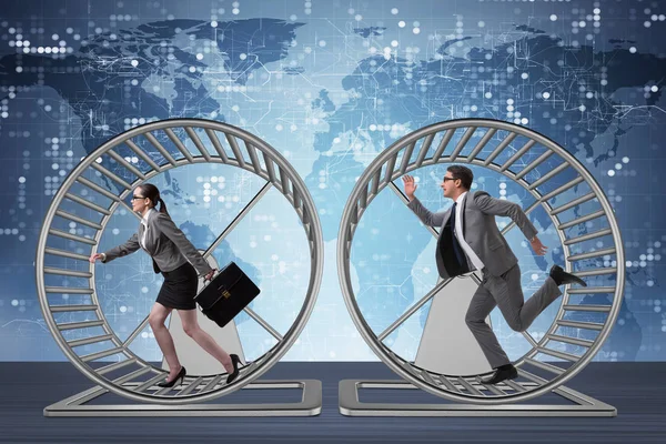 Бизнес-концепция с парой, работающей на колесе хомяка — стоковое фото