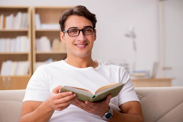 Homem leitura livro sentado no sofá sofá — Fotografia de Stock