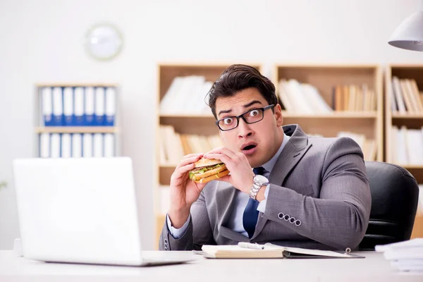 Hungry funny businessman eating junk food sandwich — Stock Photo, Image