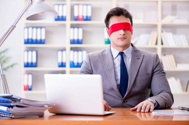 Ofiste masasında oturan gözü bağlı iş adamı.