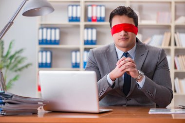 Ofiste masasında oturan gözü bağlı iş adamı.