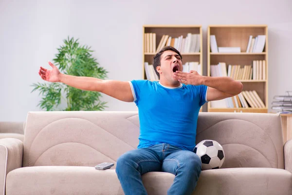 Mężczyzna ogląda piłkę nożną w domu siedzi na kanapie — Zdjęcie stockowe