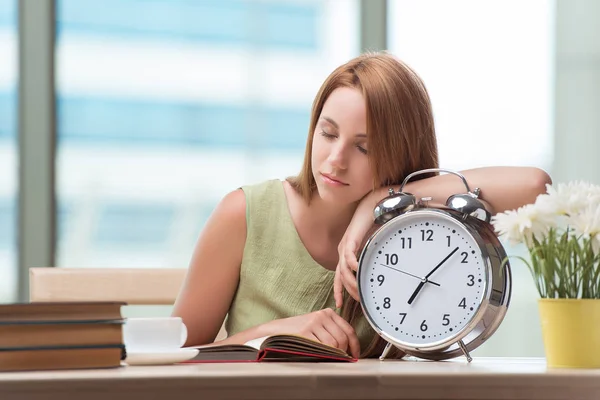 Student with gian alarm clock preparing for exams — Stock Photo, Image