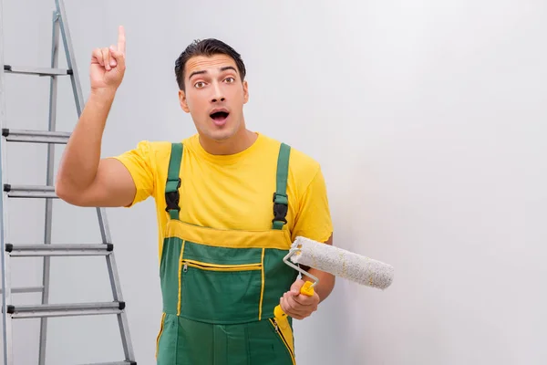 Uomo che dipinge il muro nel concetto di fai da te — Foto Stock