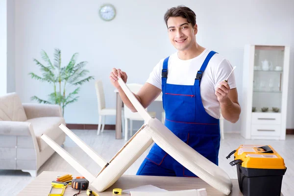 Mann repariert Stuhl im Zimmer — Stockfoto