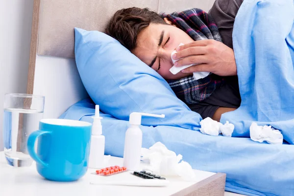 Kranker kranker Mann im Bett nimmt Medikamente und Medikamente — Stockfoto