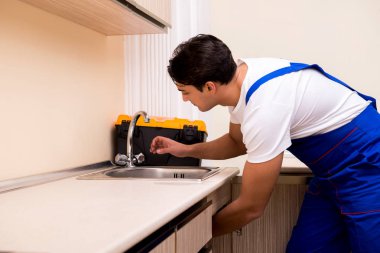 Mutfakta çalışan genç tamirci.