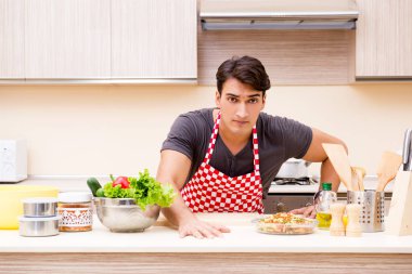 Erkek aşçı mutfakta yemek hazırlıyor.