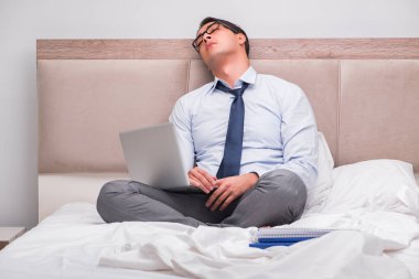 İş adamı evdeki yatakta çalışıyor.