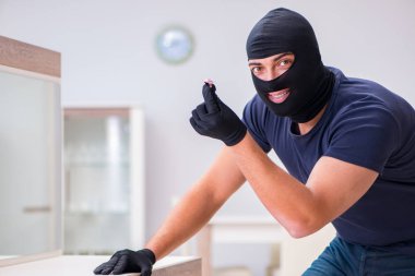 Soyguncu kar maskesi takıp değerli şeyler çalıyor.