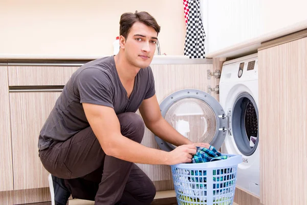 Jovem marido fazendo lavanderia em casa — Fotografia de Stock