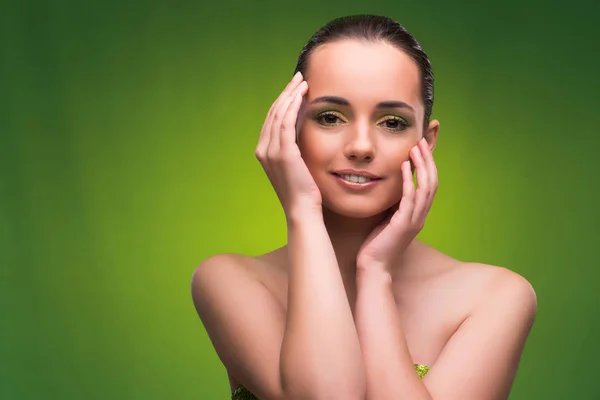 Mujer joven en concepto de belleza sobre fondo verde —  Fotos de Stock