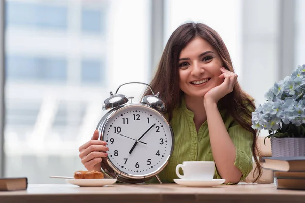 Student with gian alarm clock preparing for exams — Stock Photo, Image