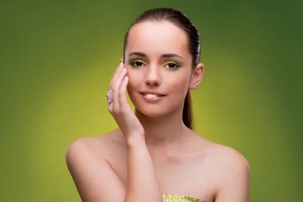 Mujer joven en concepto de belleza sobre fondo verde — Foto de Stock