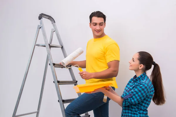 Jovem casal parede de pintura em casa — Fotografia de Stock