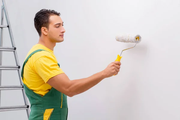 Человек рисует стену в концепции DIY — стоковое фото