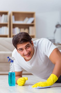 Koca adam evi temizliyor, karısına yardım ediyor.