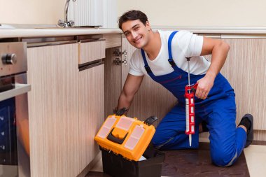 Mutfakta çalışan genç tamirci.