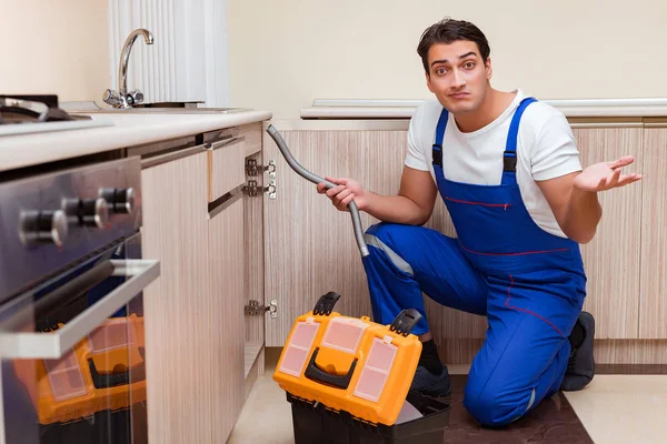 Junger Reparateur arbeitet in der Küche — Stockfoto