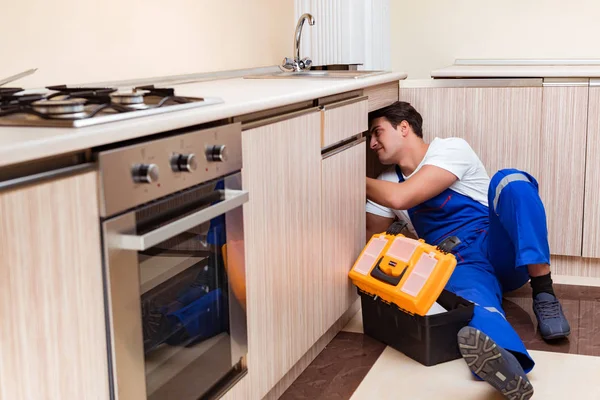 Junger Reparateur arbeitet in der Küche — Stockfoto