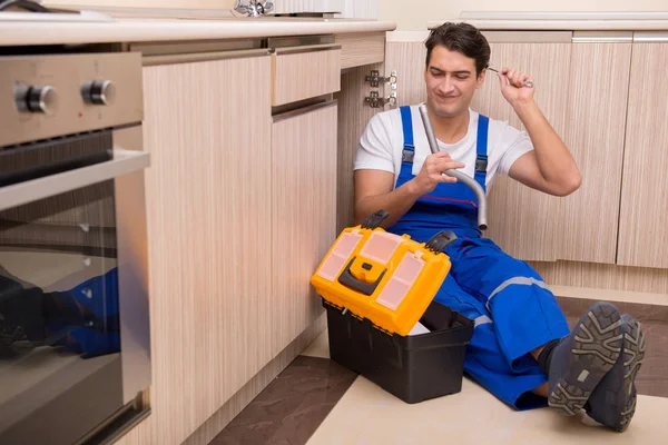 Ung reparatör som arbetar i köket — Stockfoto