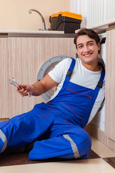 Reparateur repariert Waschmaschine in der Küche — Stockfoto